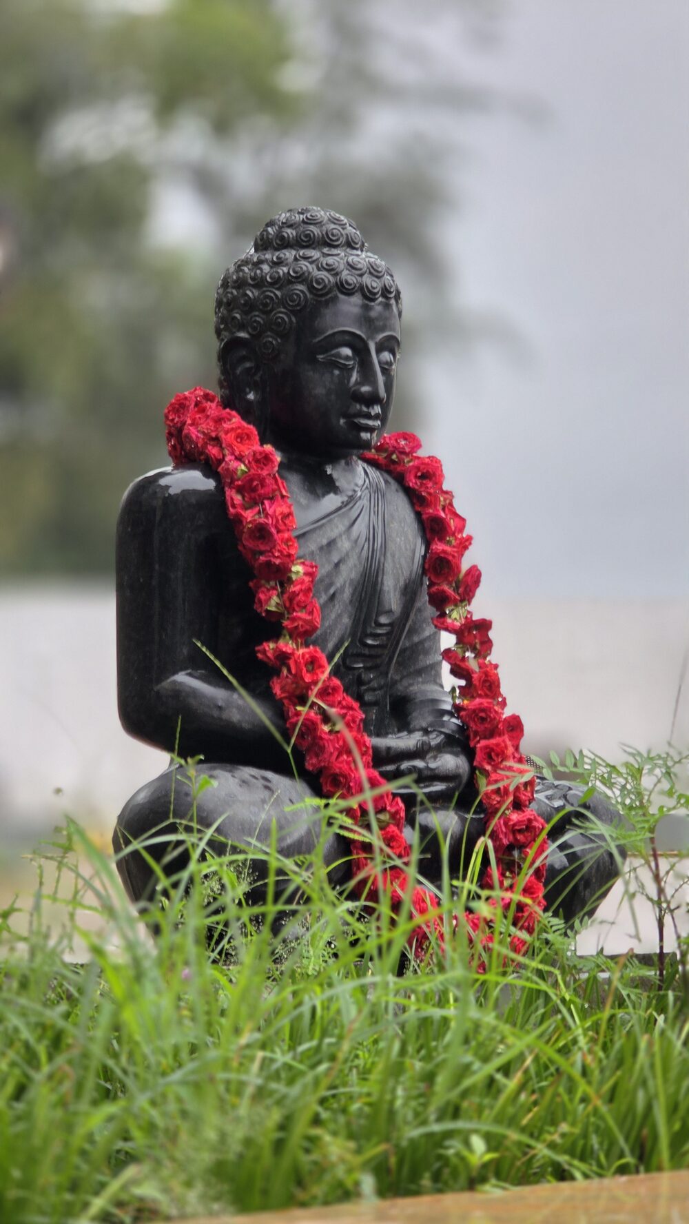 Garden detail with a garlanded statue among greenery