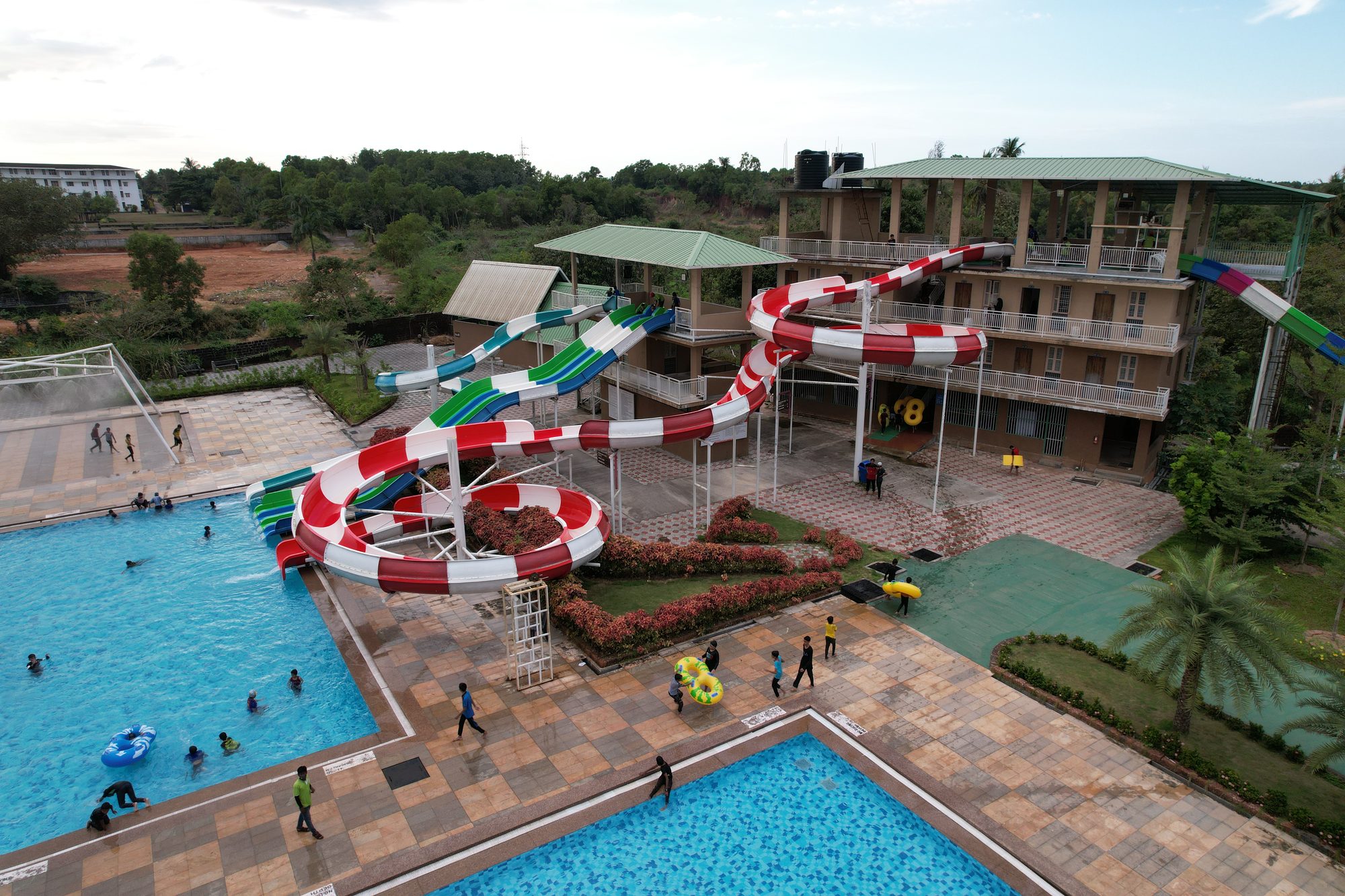 Aerial view of the multi-lane water slide tower and pool at UVA Meridian, with visitors swimming and sliding