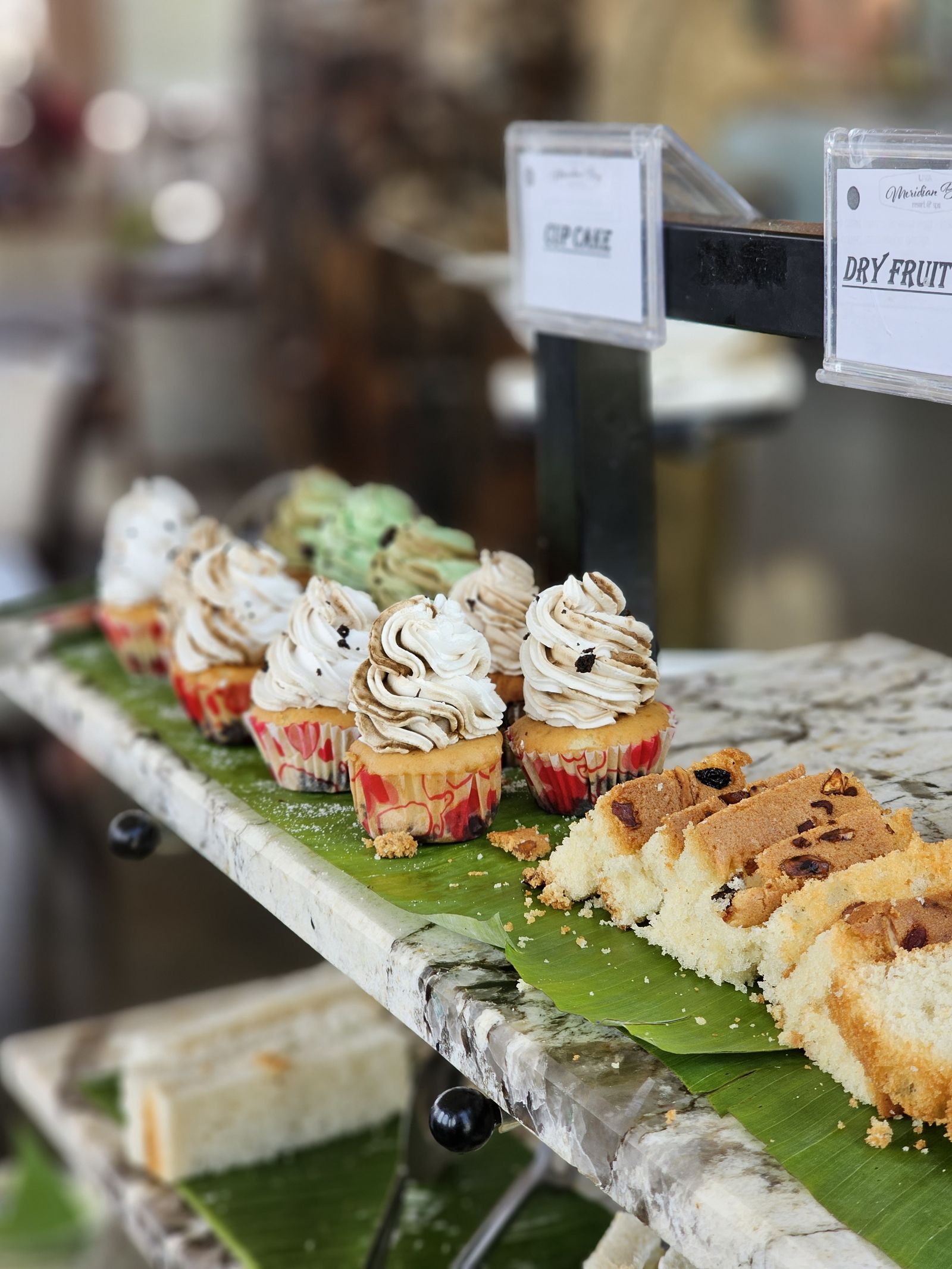 Cupcakes and dry fruit cake display at Brownies bakery, UVA Meridian